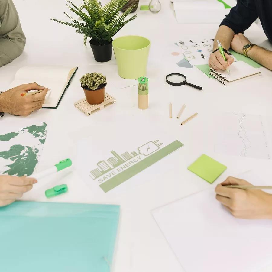 Teamarbeit an einem Tisch mit Unterlagen zu Nachhaltigkeit und Energieeinsparung